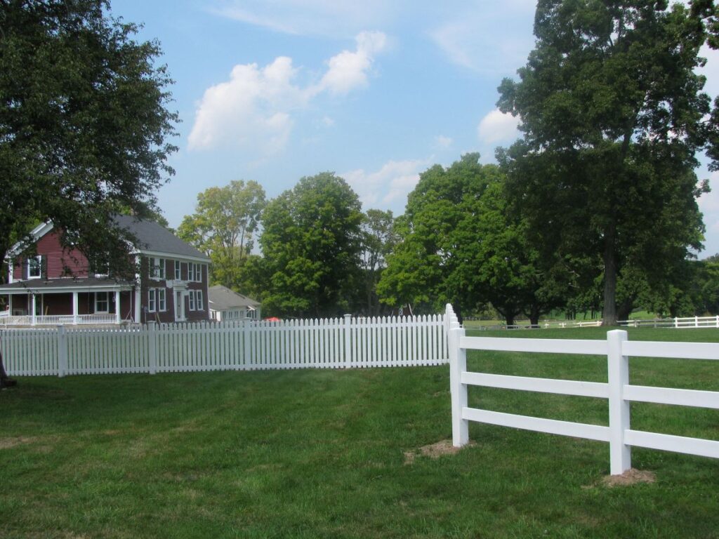 Large backyard with a white vinyl fence