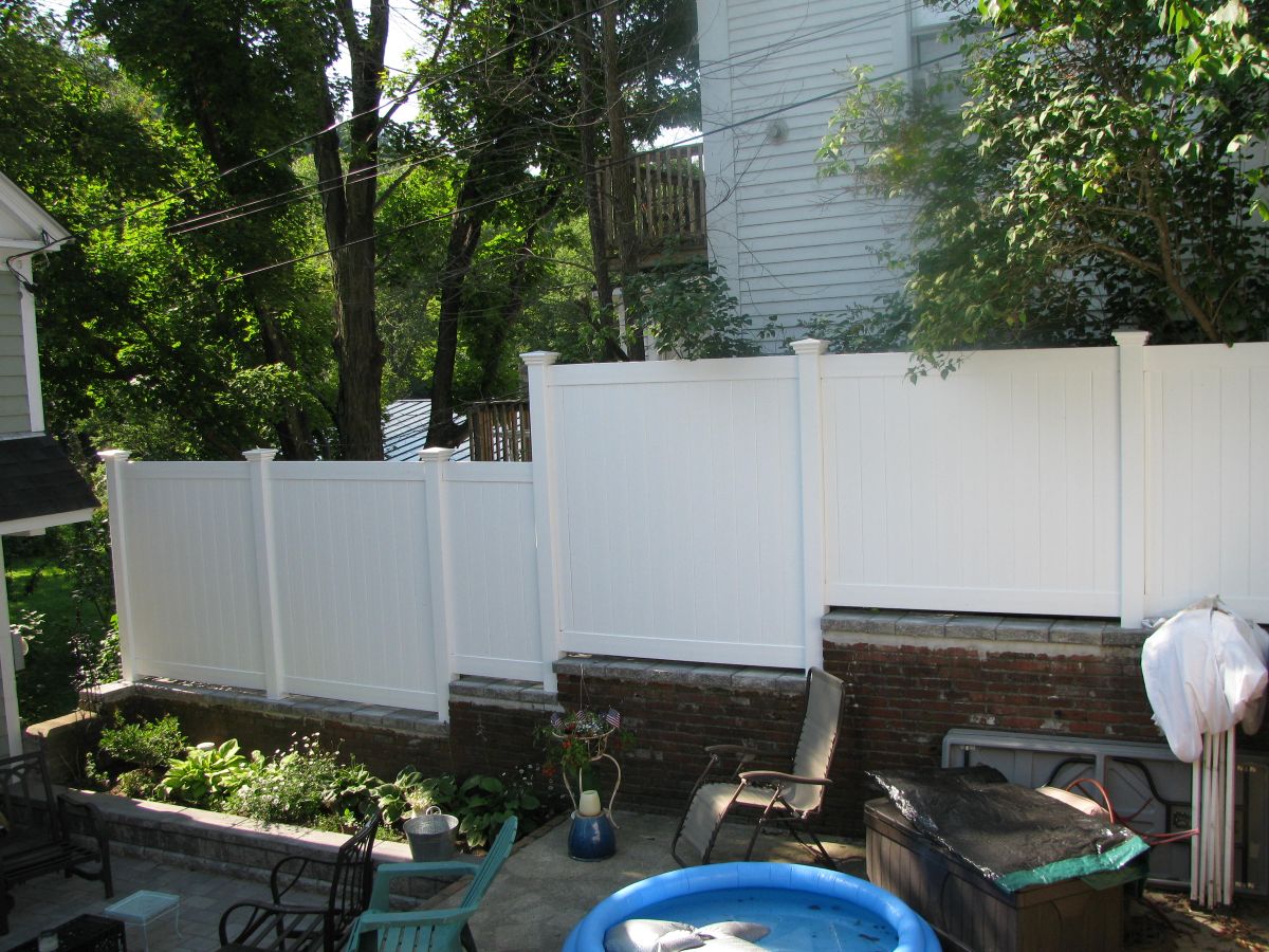 white vinyl privacy fence in a backyard