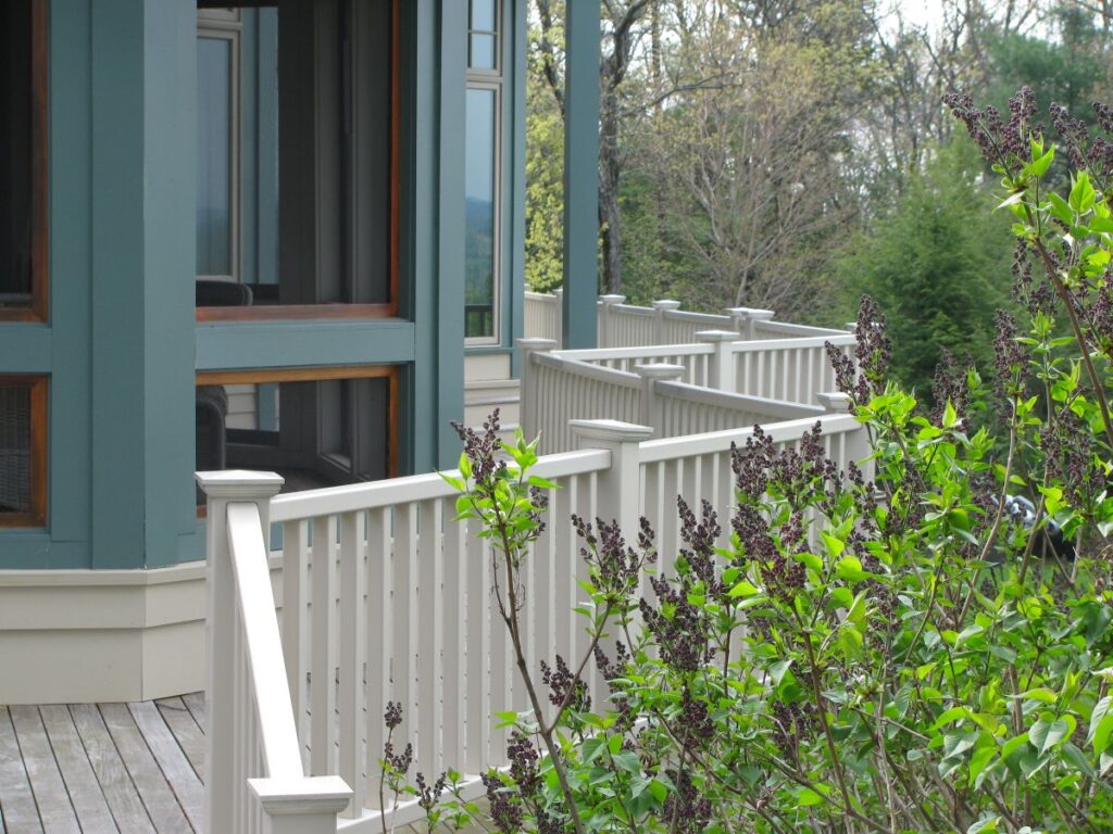 White deck railing next to greenery