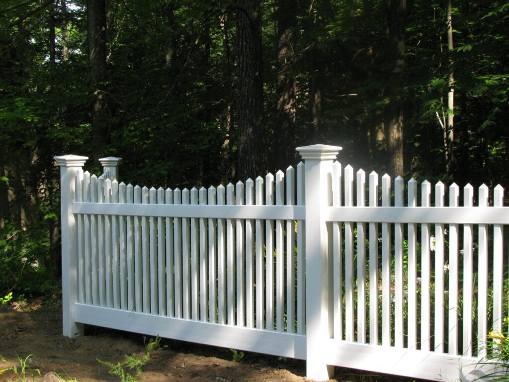 White vinyl picket fence in a backyard