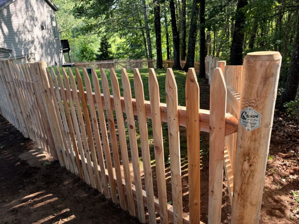 wooden picket fence in a backyard