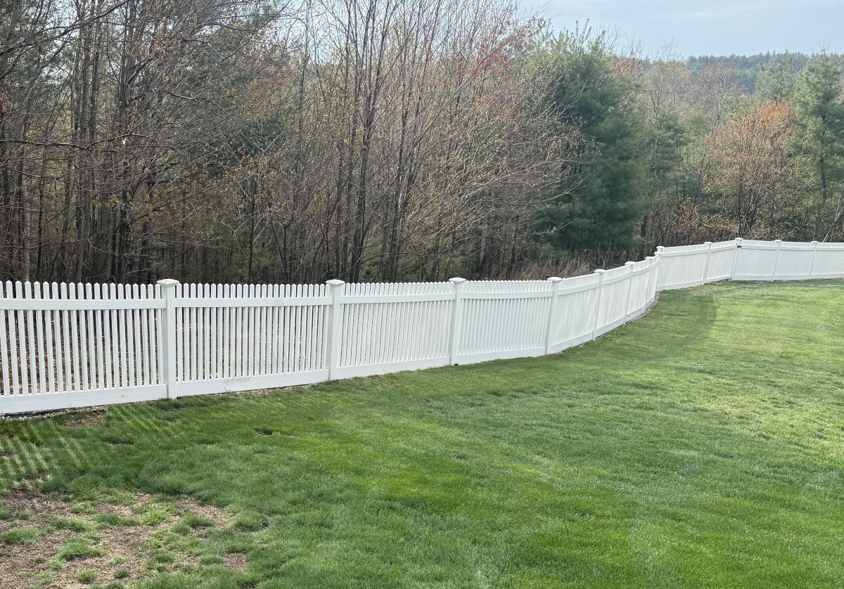 White vinyl fence across a yard