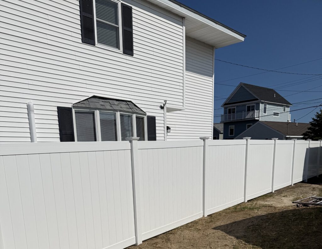 A white vinyl privacy fence surrounding a house
