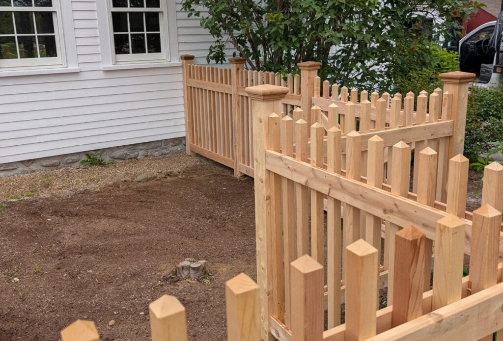 wooden picket fence in a yard