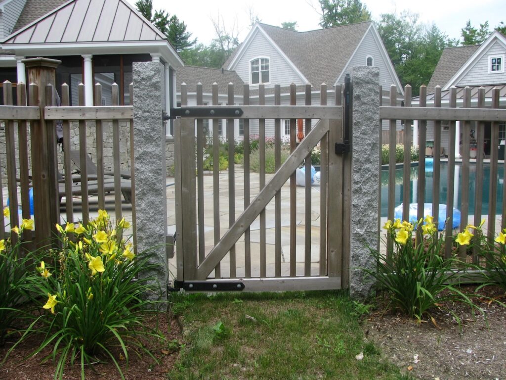 A fence with a gate leading to a yard