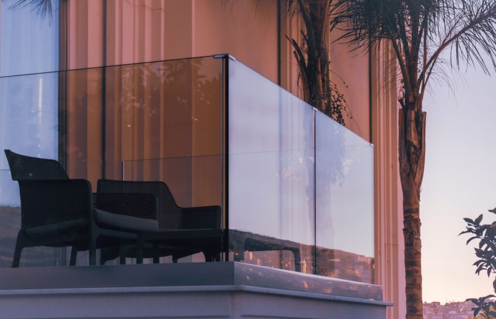 modern design glass deck railing two black chairs summer weather nice view
