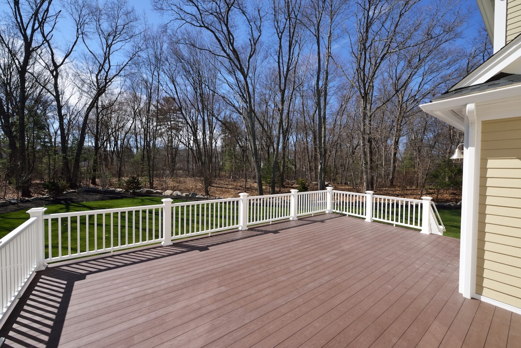 wooden deck with white vinyl railing