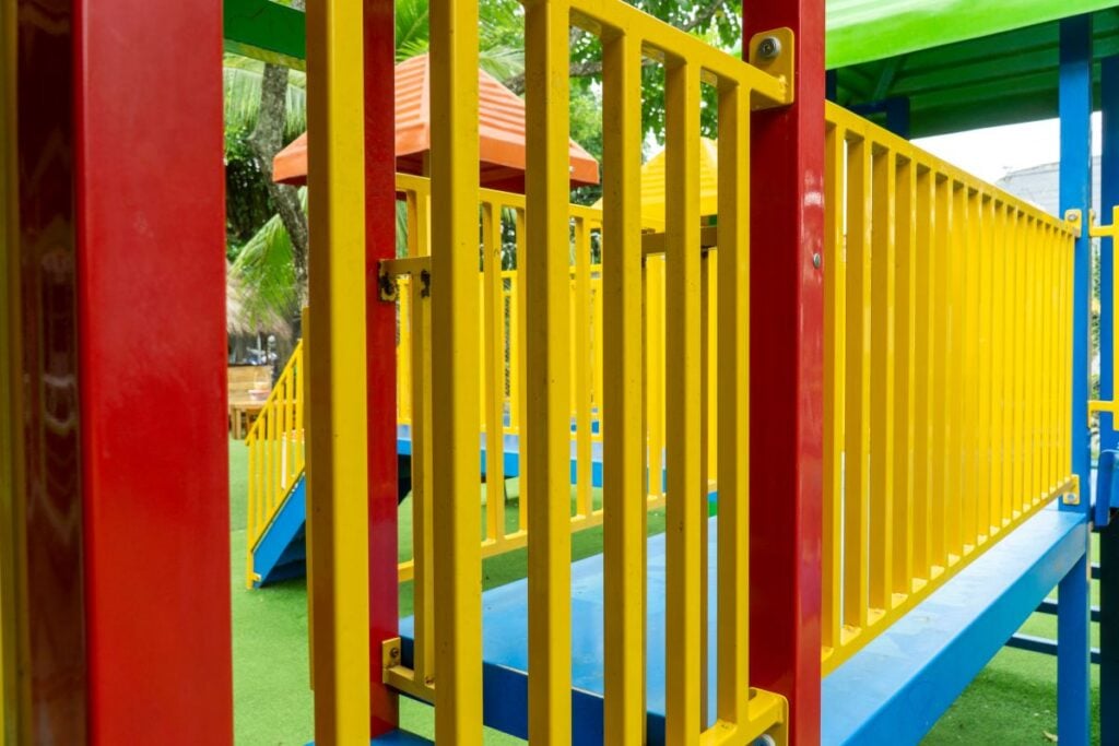 Close-up of a colorful outdoor children playground structure featuring vibrant railings