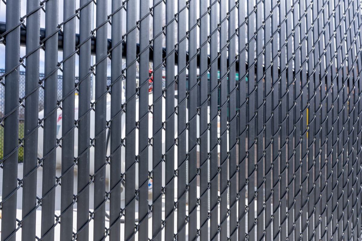 Black vinyl coated chain link fence with vertical black privacy slats