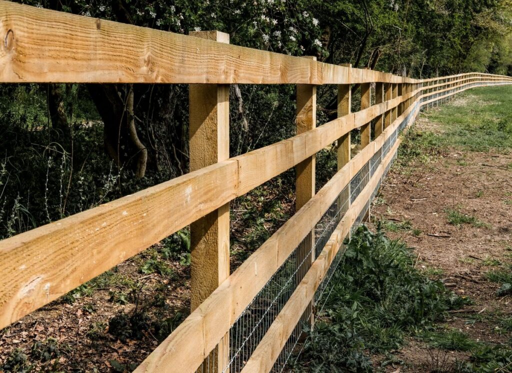 Newly installed timber fencing seen at the perimeter to a large grazing field