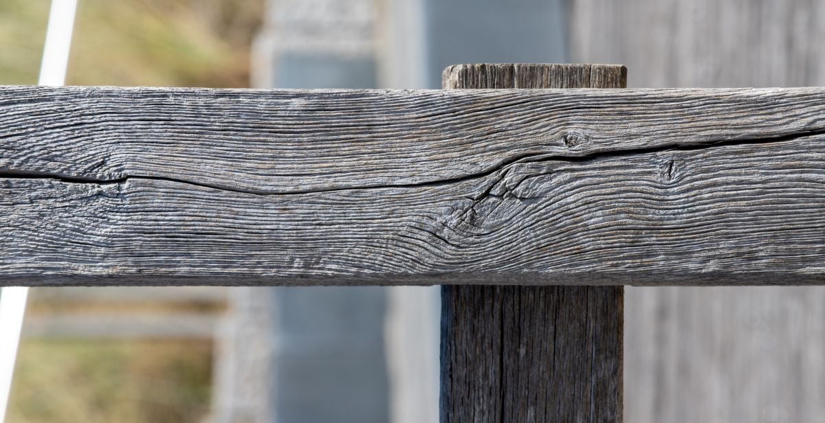 Old weathered wooden fence rail texture with natural grain and cracks