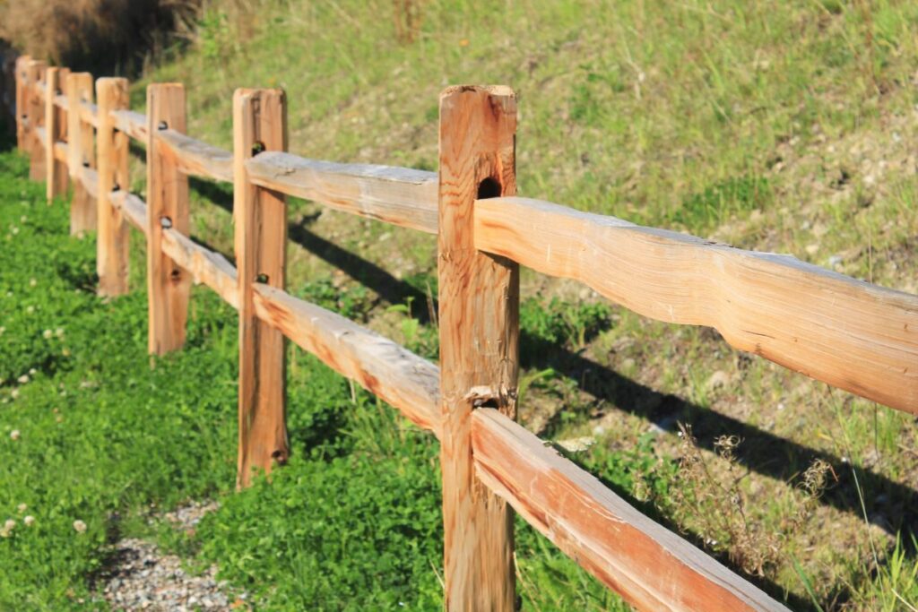 Split rail fence along a grassy hillside