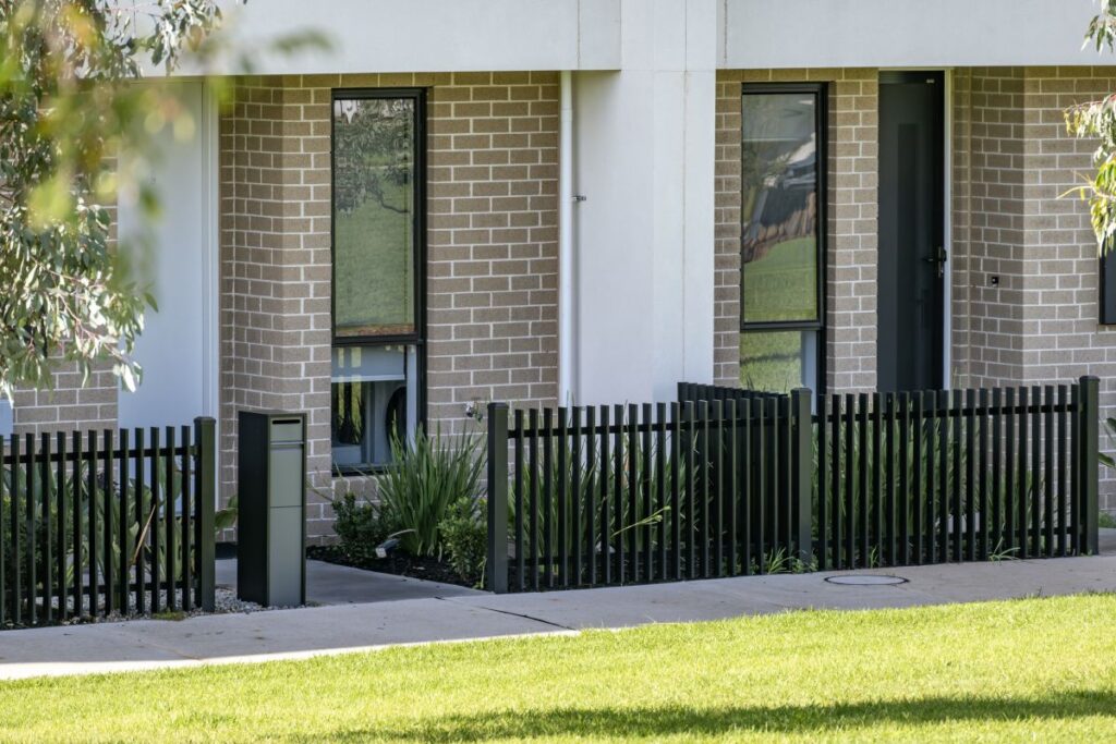 Street view of modern townhouses featuring aluminium picket fencing