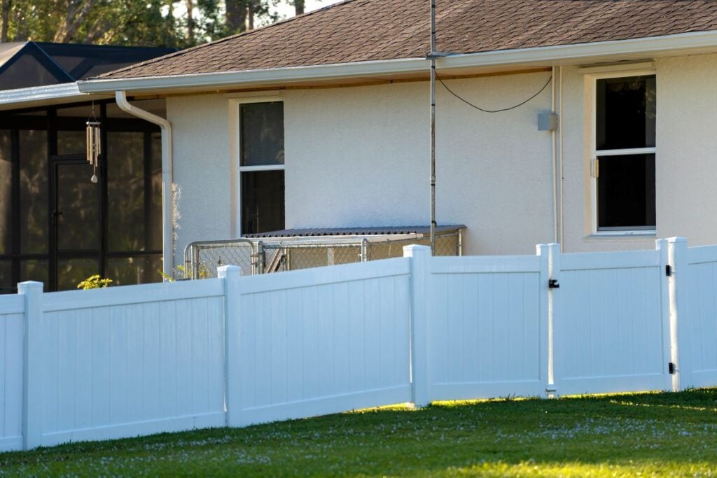 White vinyl picket fence with a gate