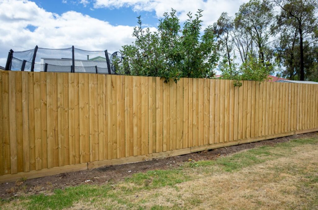 a newly installed timber garden fence in the suburban backyard of a residential house