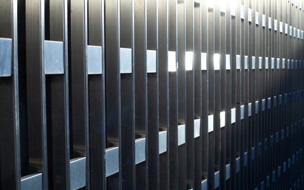 grey, high iron fence enclosing the territory
